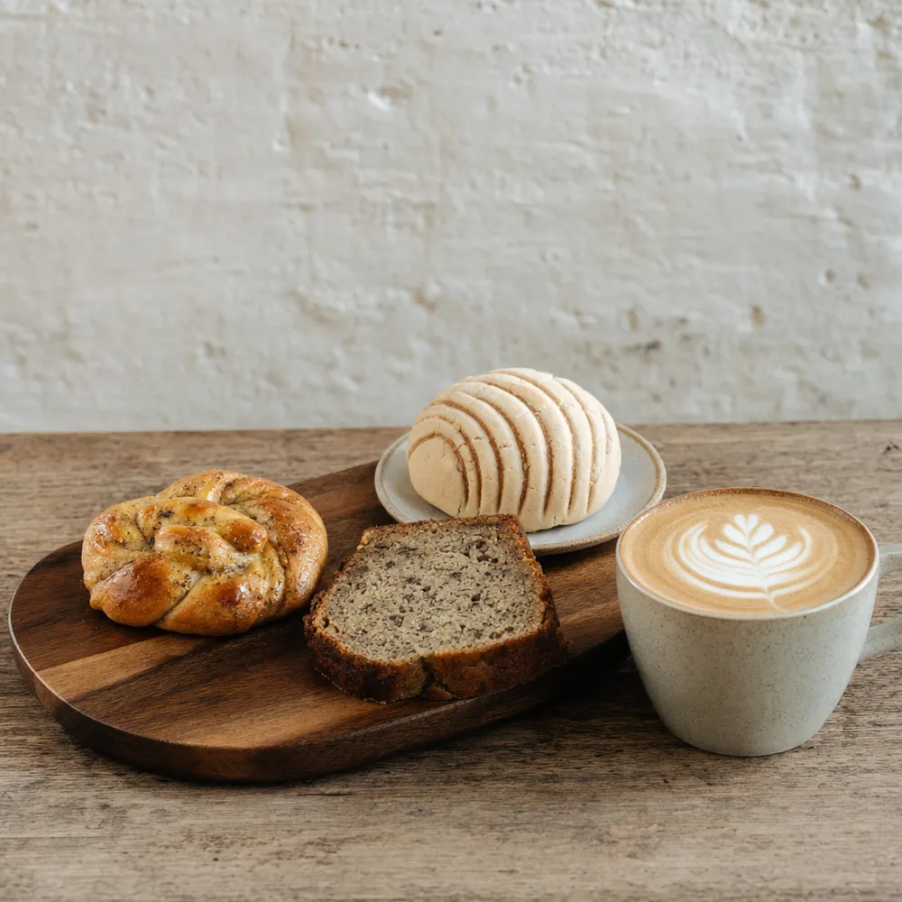 Tabla con pan de cardamomo, pan de banano y capuchino